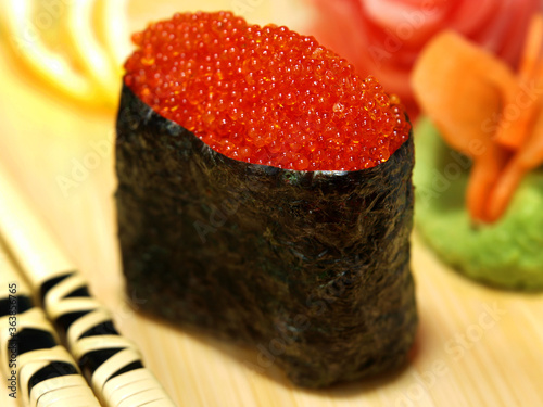 Sushi gunkan with tobiko caviar on a wooden tray close-up photo