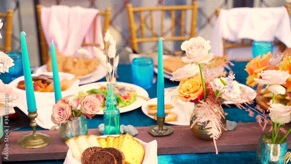 Decor in a rustic style. The outdoor terrace in the restaurant is decorated to celebrate a small wedding. Table decoration in blue, yellow, red bright colors. Nature micro wedding. 