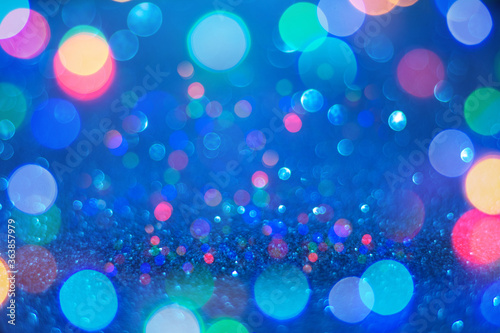 Christmas and New Year background. Defocused multi color bokeh on a blue background
