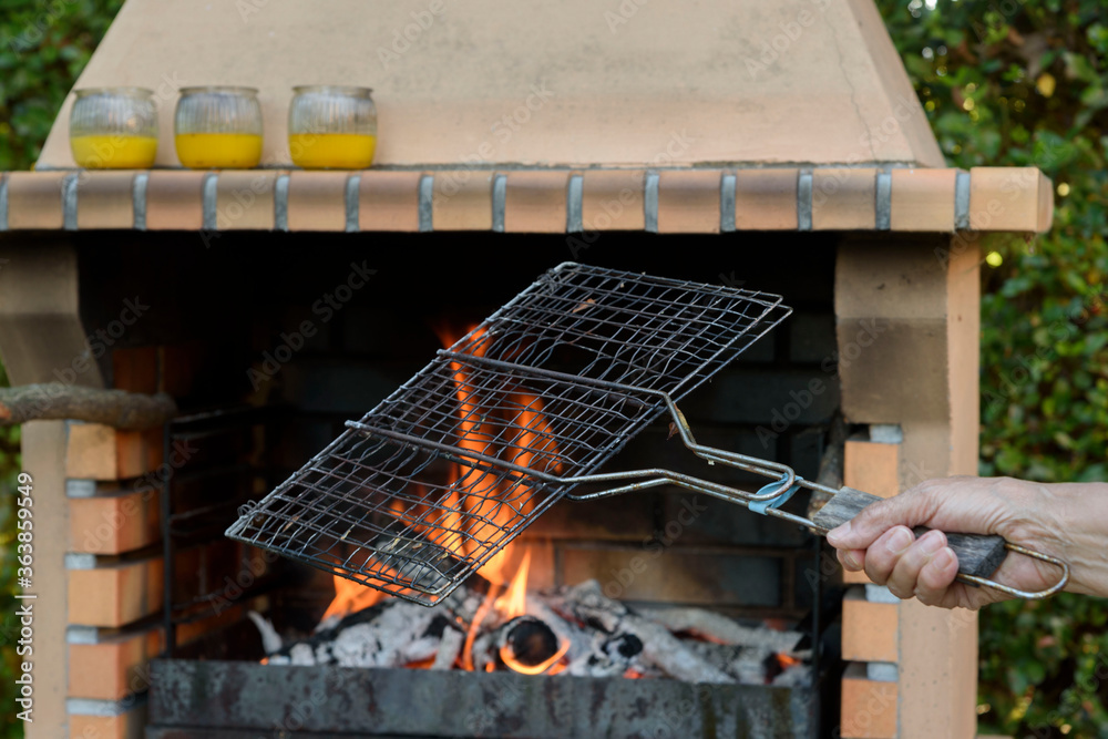 Barbecue lit and with flames, prepared to grill food on the outside. Eat in the garden. Barbecue lit and with flames, prepared to grill food on the outside. Eat in the garden.