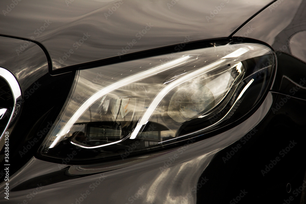 Car headlights. Luxury Headlights. Part of a black car.