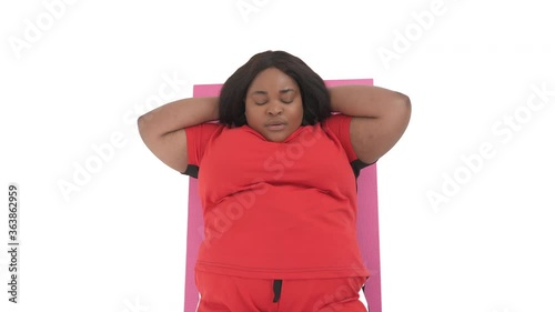 front view portrait of black woman with overweight doing abdominal crunches isolated on white background photo