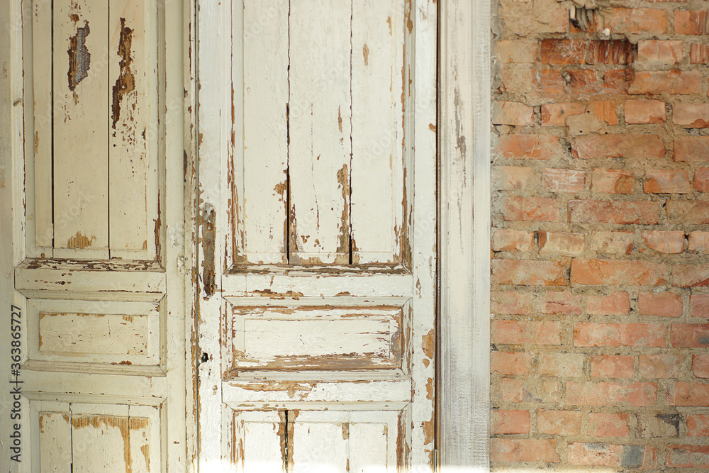 Old, white painted doors, closed, indoors with red brick walls