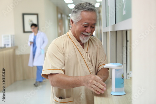 Happy senior patient cleaning hand at hospital