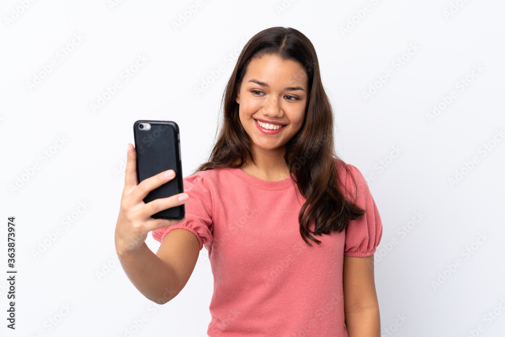 Young Colombian girl over isolated white background making a selfie