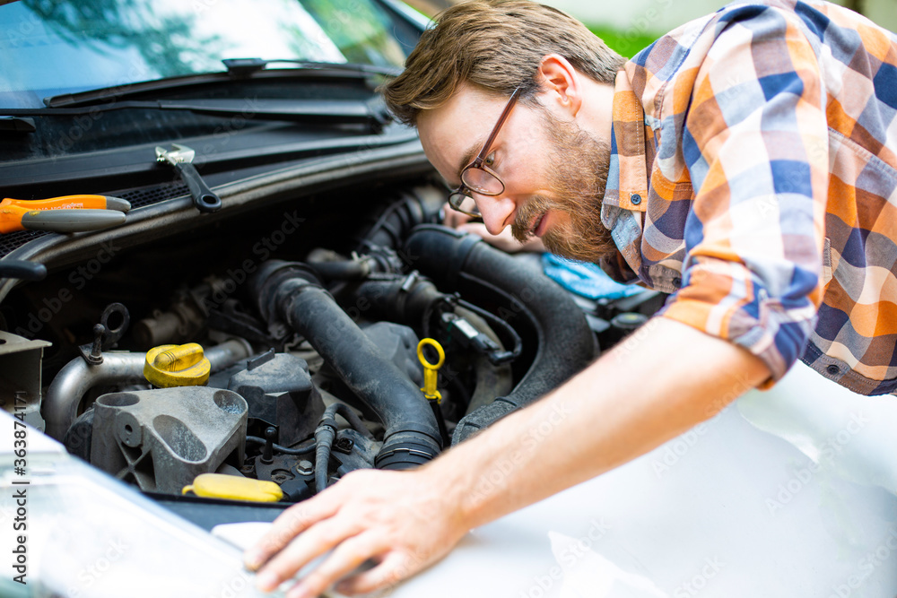 A man fixing a car on a sunny day. Self automobile repair. A man fixing a car on a sunny day. Self automobile repair.