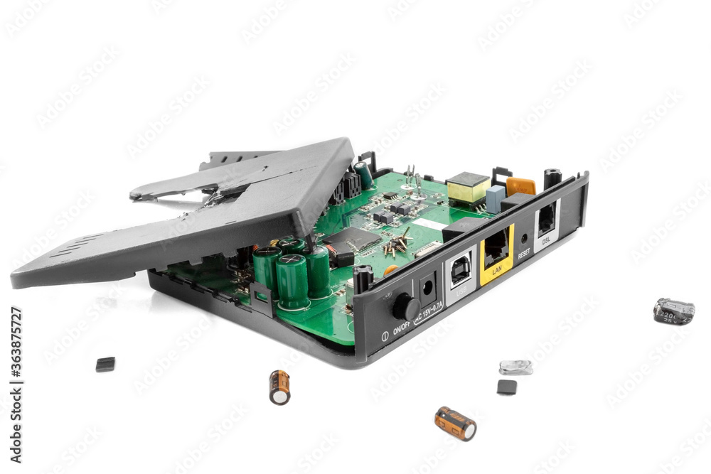 Fragmented Internet Modem Router on a white background close-up. Around lying parts of it. Fragmented Internet Modem Router on a white background close-up. Around lying parts of it.