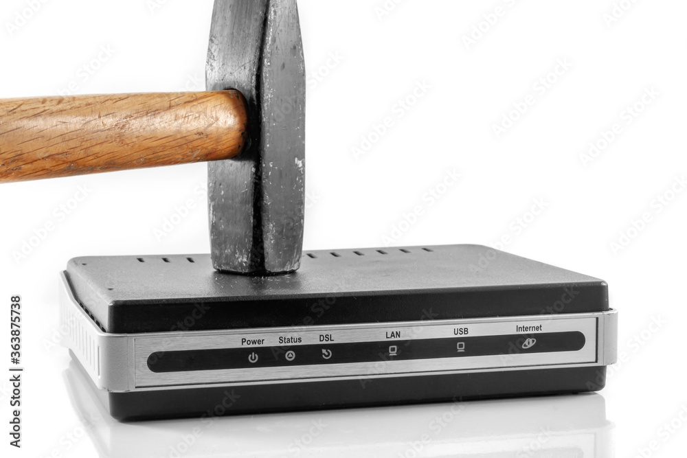 Hammer strikes the interenet modem router to break it. Day free from the Internet. On a white background close-up. Hammer strikes the interenet modem router to break it. Day free from the Internet. On a white background close-up.