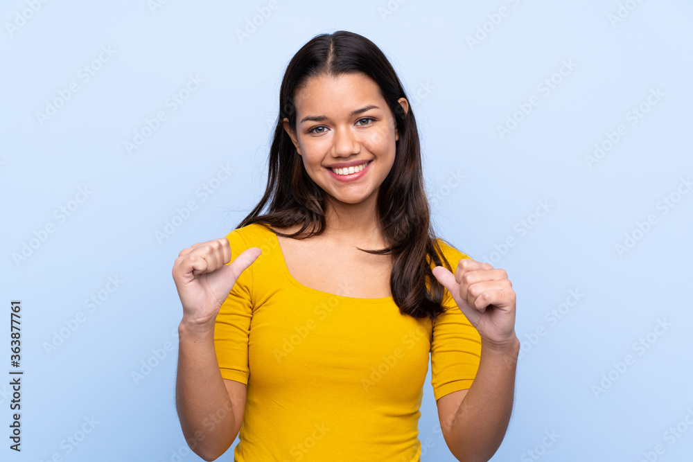 Young Colombian girl over isolated blue background proud and self-satisfied Young Colombian girl over isolated blue background proud and self-satisfied