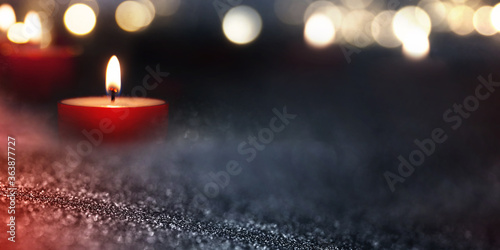 Burning candle a sign of hope Candlelight in the darkness with blurred golden bokeh. Background with short depth of field for religious rituals and spiritual meditation or grief.