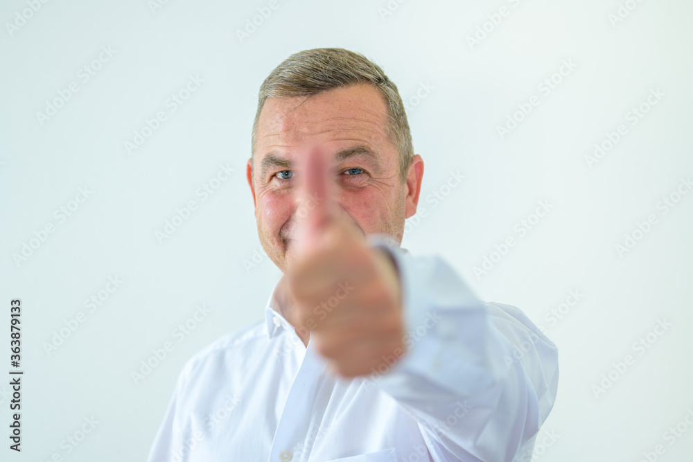 Middle-aged man giving a thumbs up gesture Middle-aged man giving a thumbs up gesture