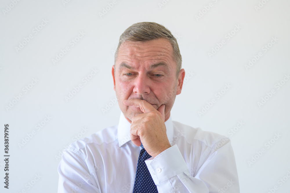Worried anxious businessman with hand to chin Worried anxious businessman with hand to chin