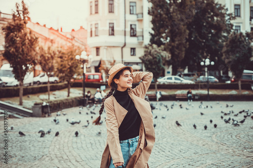 Young inspired female in straw hat enjoying her trip, waking down the street and squares. photo