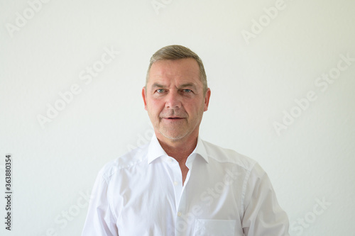 Serious middle-aged man in smart white shirt