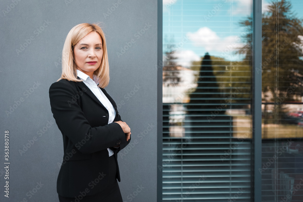 Portrait of a serious secretary against the background of office window Portrait of a serious secretary against the background of office window