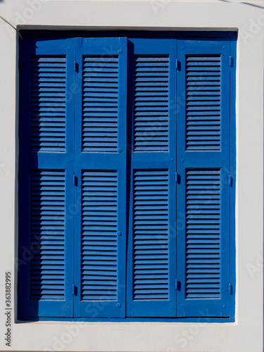 Lovely blue wooden shutters in greece  rustic and romantic background.
