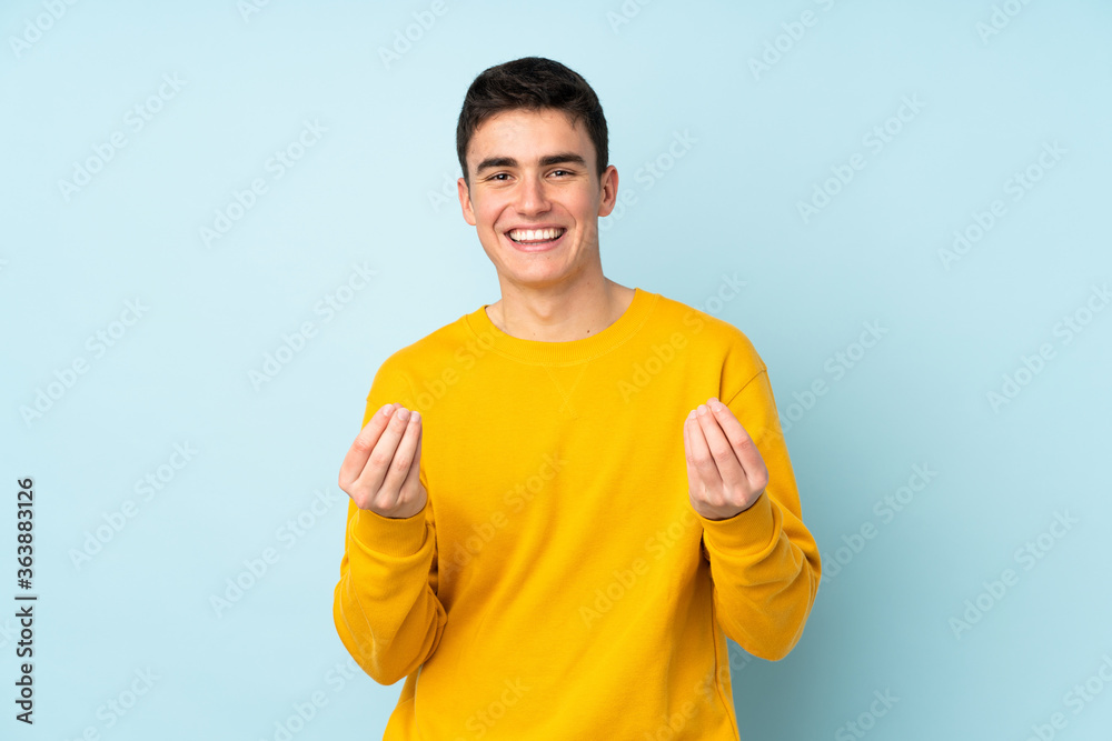 Teenager caucasian handsome man isolated on purple background making money gesture Teenager caucasian handsome man isolated on purple background making money gesture