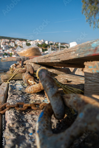 Samos island. Greece. Sea and pythagorion village background. with collorful boats. in the front a big knot and chains
