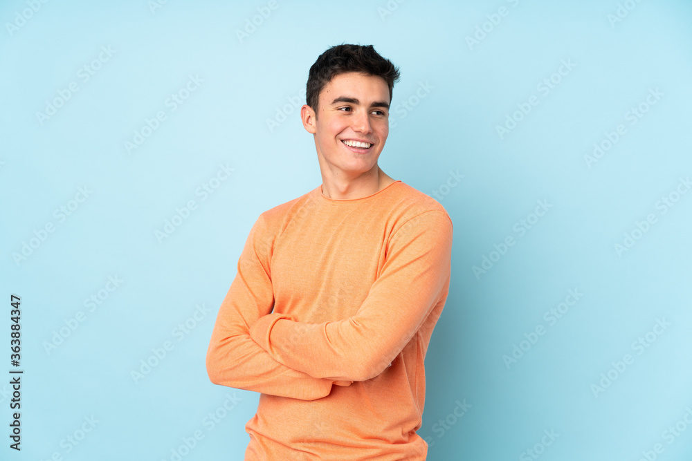 Teenager caucasian handsome man isolated on purple background laughing