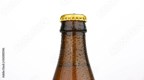 Brown beer bottle rotating over white