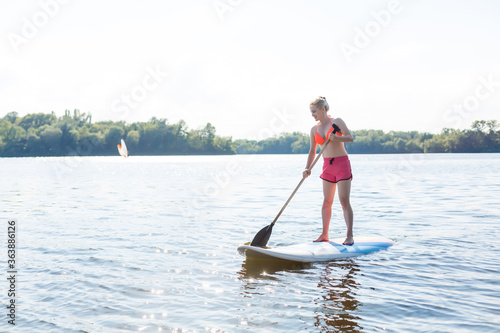 A beautiful woman practicing paddle on a beautiful sunny day © Angelov