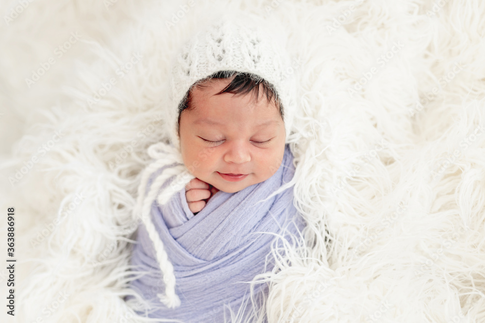 Smiling newborn in knitted hat