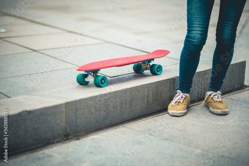 Asian woman with skatebaord in modern city