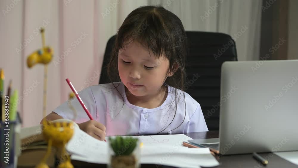 Asian little girl in preschool uniform doing school homework drawing and painting at home her was intending to do home work to send the teacher the next day Asian little girl in preschool uniform doing school homework drawing and painting at home her was intending to do home work to send the teacher the next day