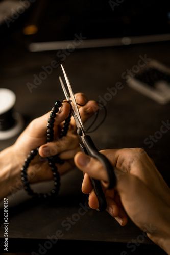 creation of a bracelet from stones, process, hands, close-up. photo