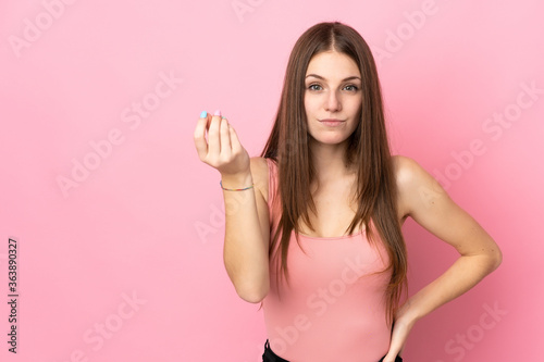 Young caucasian woman isolated on pink background making Italian gesture