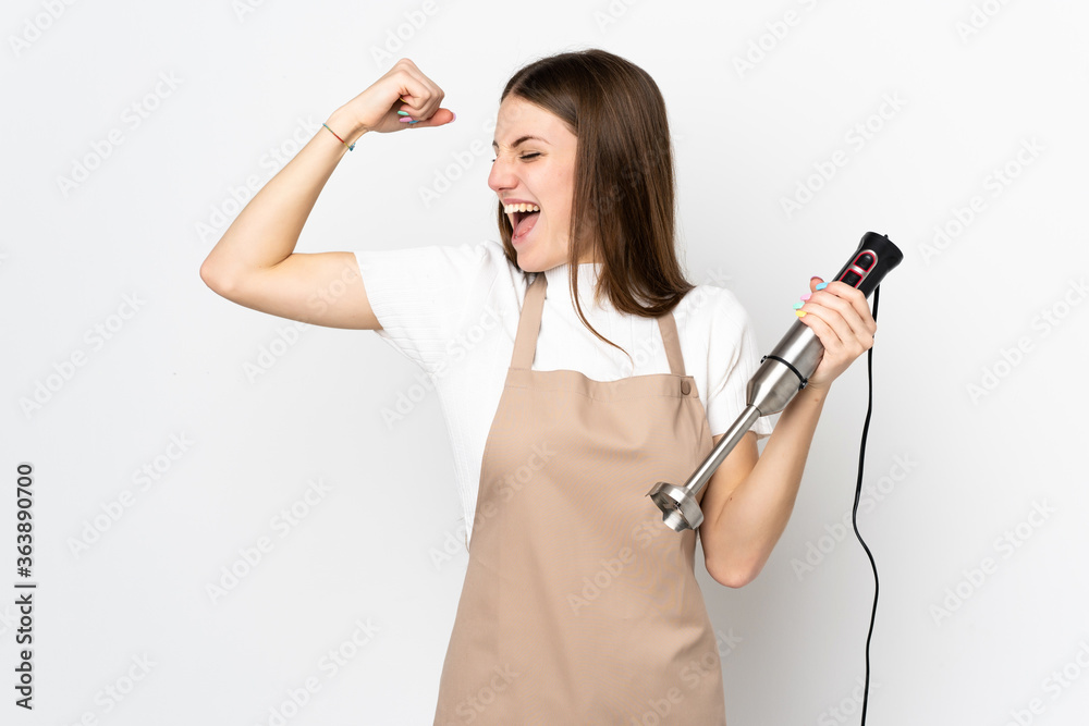 Young woman using hand blender isolated on white background celebrating a victory Young woman using hand blender isolated on white background celebrating a victory