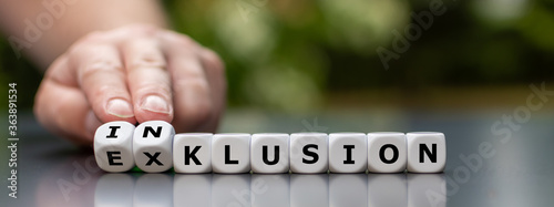 Symbol for a better inclusion. Hand turns dice and changes the German word "Exklusion" (exclusion) to "Inklusion" (inclusion).