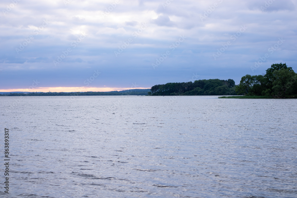 Sunset and blue clouds over the lake. Plenty of room for text.