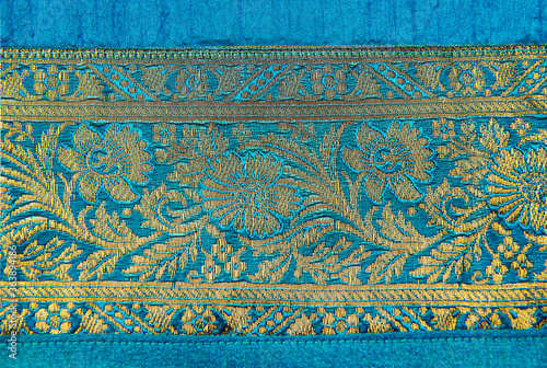 A border of an Indian fabric with intricate ornamental design. Details of an exotic Indian saree or fabric.