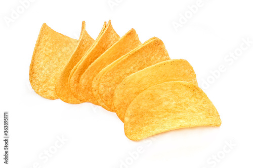 Pile of crispy potato chips isolated on white background. Unhealthy junk food with calories 