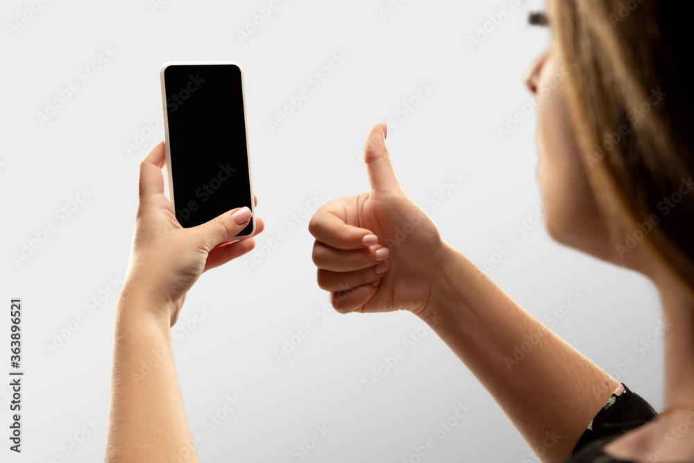 Thumb up, like. Close up female hands holding smartphone with blank screen during online watching of popular sport matches, championships. Copyspace for ad. Devices, gadgets, technologies concept.