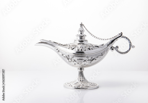 Silver Alladdin lamp- an object from Arabian tales shot on on white background.