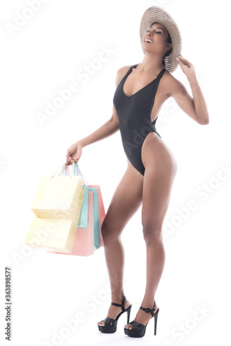 Happy asian shopping woman wear swiming suit hold shopping bags in hand enjoy in lifestyle shopping concept, in midnight sales and discount on seales. photo