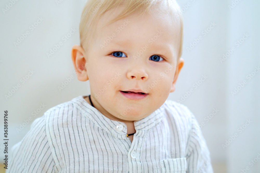 Closeup baby boy with blue eyes and blonde hair smiling at camera Closeup baby boy with blue eyes and blonde hair smiling at camera