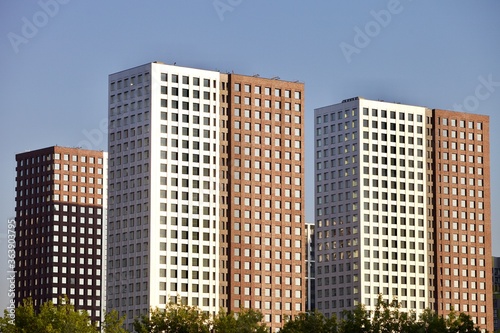 Residential skyscrapers on clear blue sky background. Commercial real estate.  Modern residential city district. Apartment buildings architecture. New Property For Sale. New buildings exterior design.