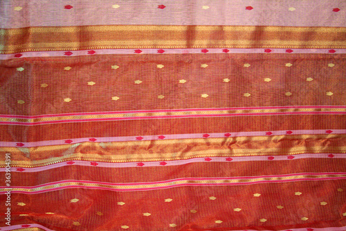 Maheshwari saris in a textile shop, displayed in front of customers. Maheshwar, Madhya Pradesh, India. photo