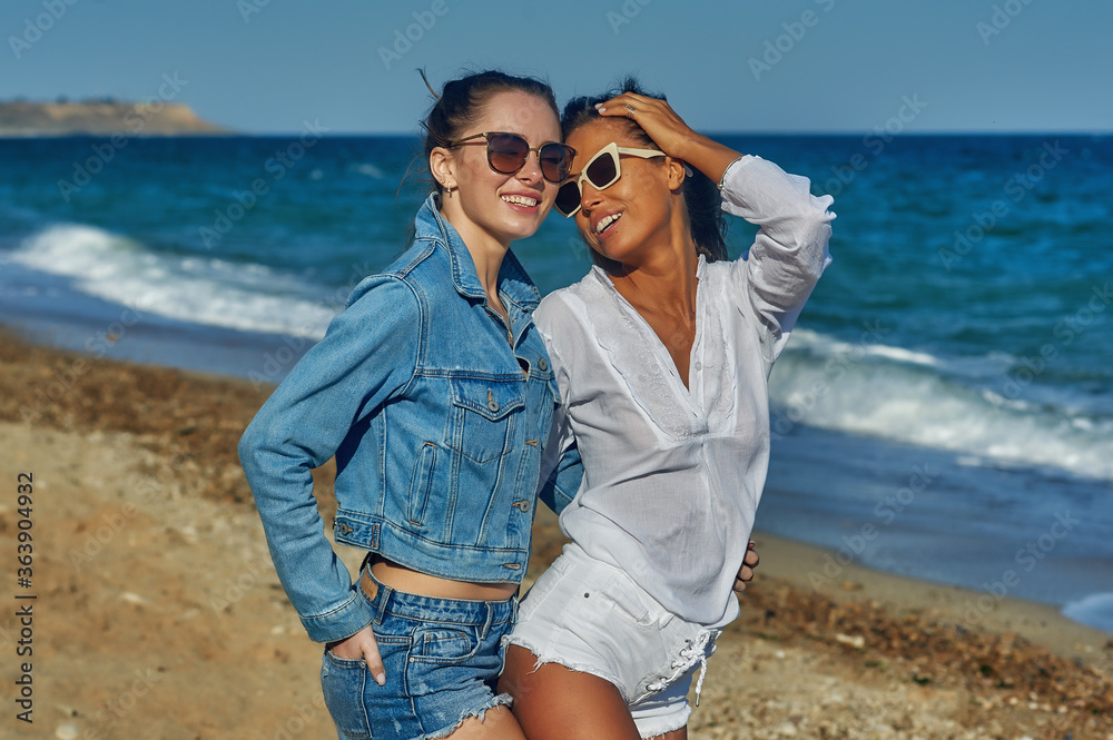 Young cheerful women on a walk along the sea