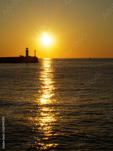 Sunrise over a lighthouse in the sea