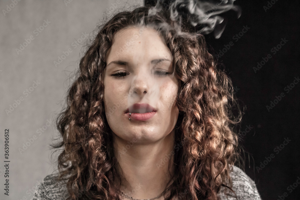 Junge Frau bläst den Rauch heraus