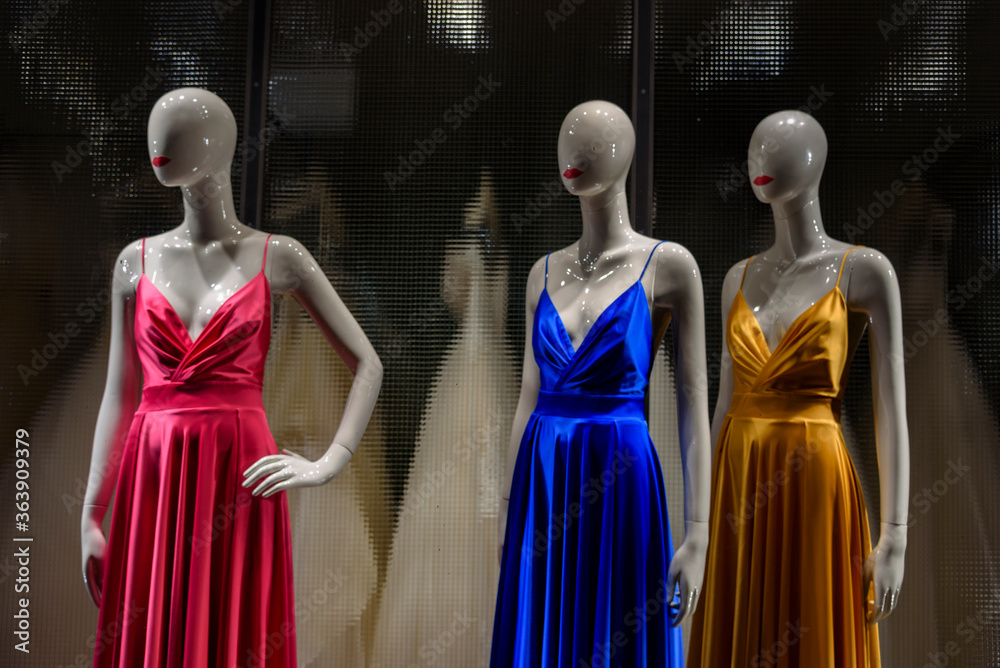 Details on mannequin of colored, red, yellow and blue women's dresses for ceremonies