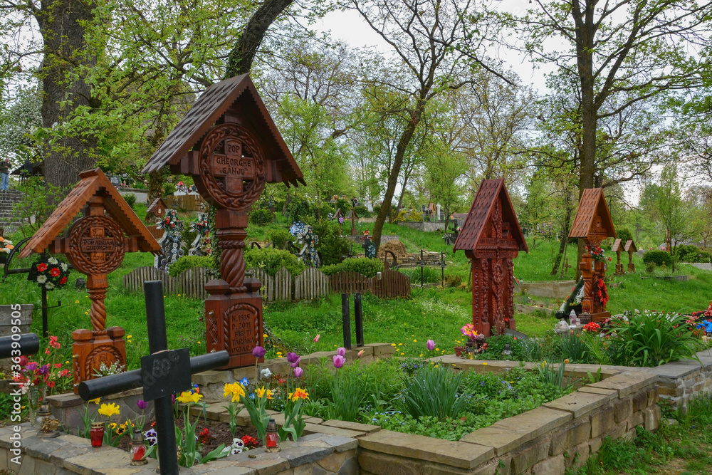 DESESTI, MARAMURES, ROMANIA, SUMMER 2018..Graves of the cemetery of the beautiful wooden orthodox church of San Parascheva or Desesti, Unesco World Heritage.