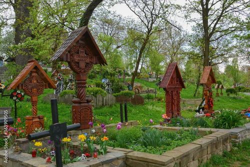 Obraz na płótnie DESESTI, MARAMURES, ROMANIA, SUMMER 2018..Graves of the cemetery of the beautiful wooden orthodox church of San Parascheva or Desesti, Unesco World Heritage. w salonie