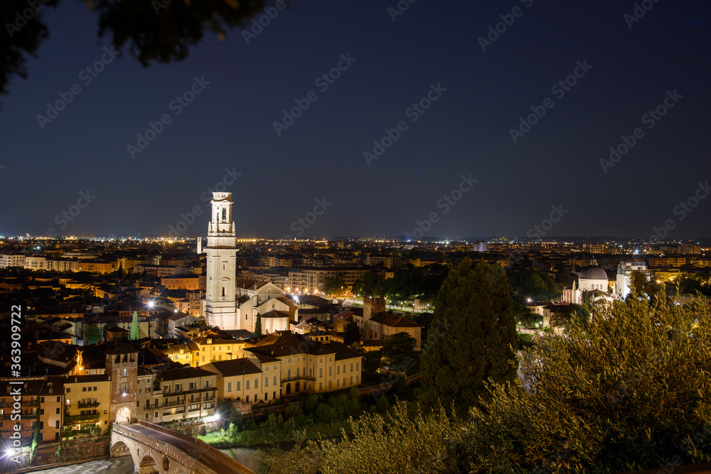 Night photo from the square of Castel San Pietro. View along Adige River with view of the Ponte della Pietra and Duomo, city of Verona, Italy.