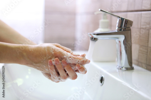 girl washes her hands with soap, hygiene and cleanliness of hands 