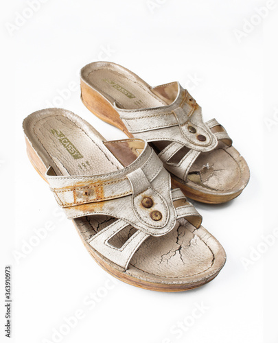 Pair of old and broken female sandals on white background photo